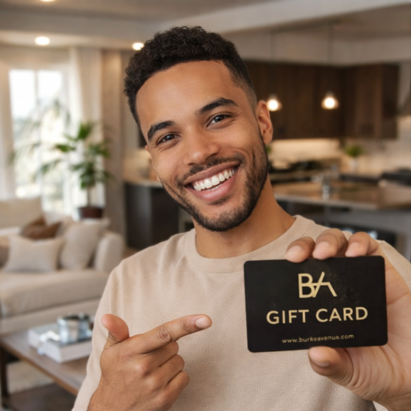 Man holding a gift card with 'BA' -Burke Avenue branding in a living room setting