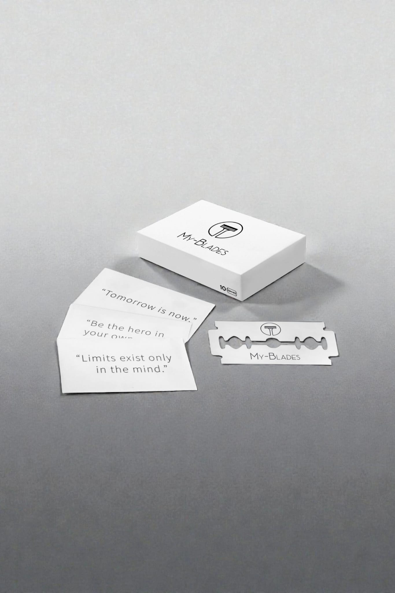 My-Blades razor blade box displayed with motivational quote cards and a single branded double-edge blade on a modern gray surface.